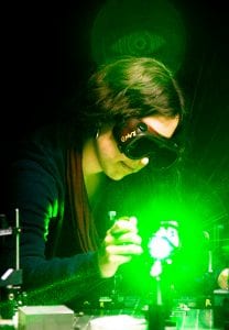 A woman working on electric machinery with a green glow