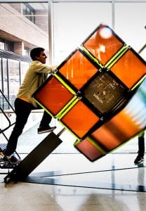 A student spins the bottom level of a giant Rubik's Cube