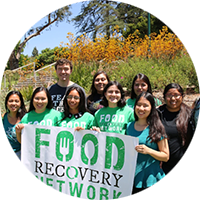 A group of students in a garden holding a large “Food Recovery Network” sign.